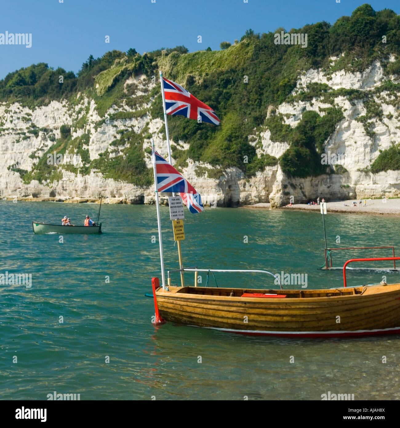 Le bateau avec deux drapeaux Union Jack survolant sur la plage de bière Devon England UK Banque D'Images