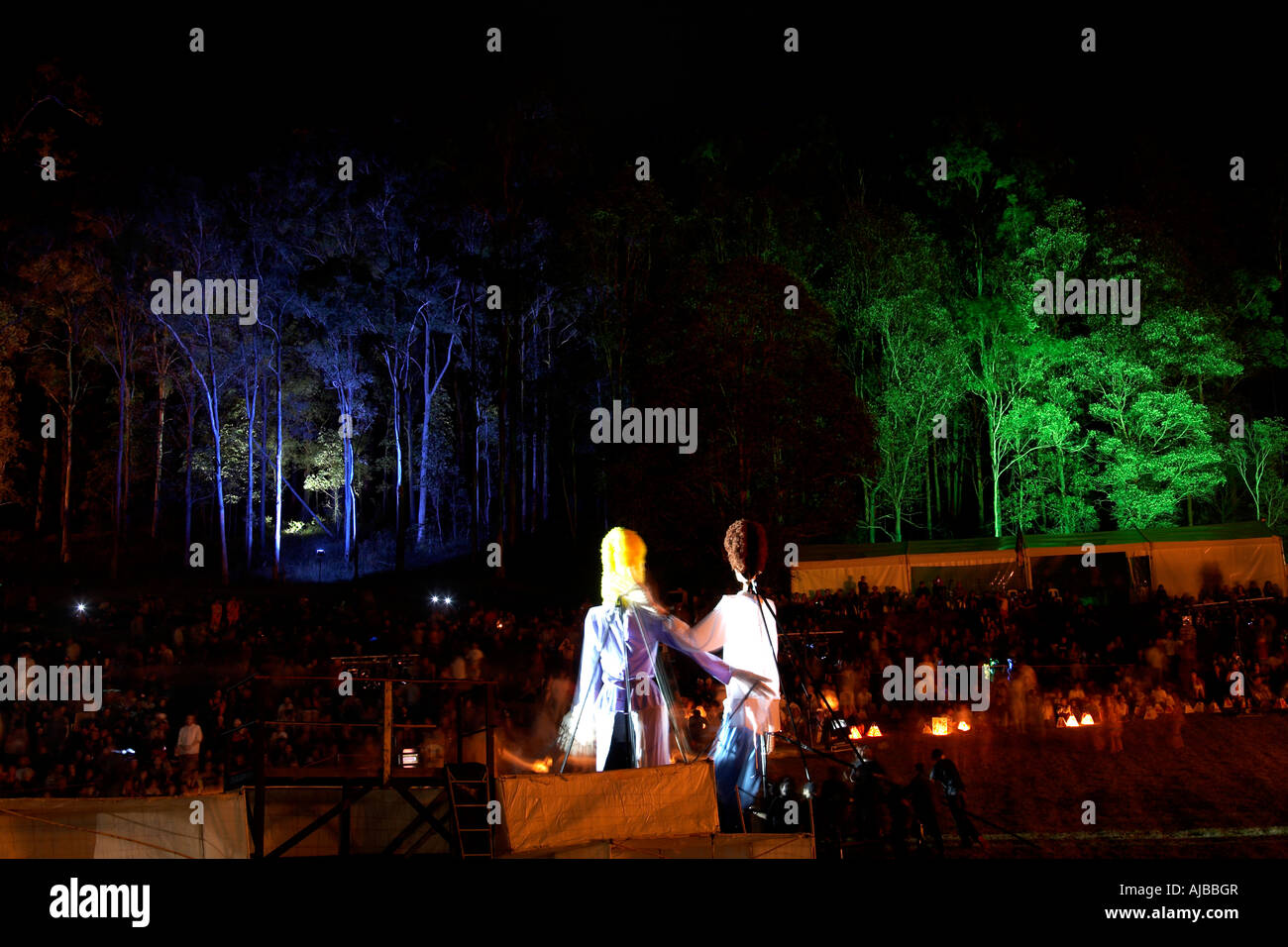 Les chiffres de marionnettes géantes avec l'illumination de l'arbre et le public dans l'amphithéâtre à incendie performance à Woodford Folk Festival Queensl Banque D'Images
