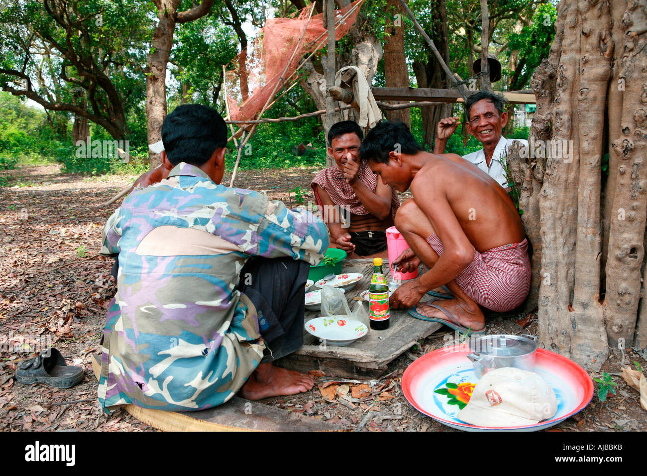 Les hommes khmers partager un repas au village de Kompong Phhluk, Tonle Sap, Nr Siem Reap, Cambodge Banque D'Images