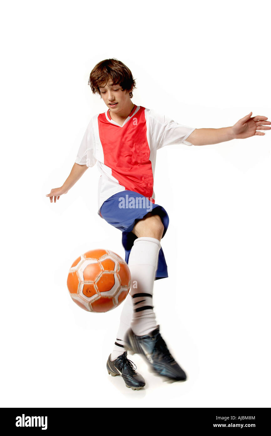 Jeune homme sur le point de frapper un ballon de soccer avec des bras Outstreched Banque D'Images
