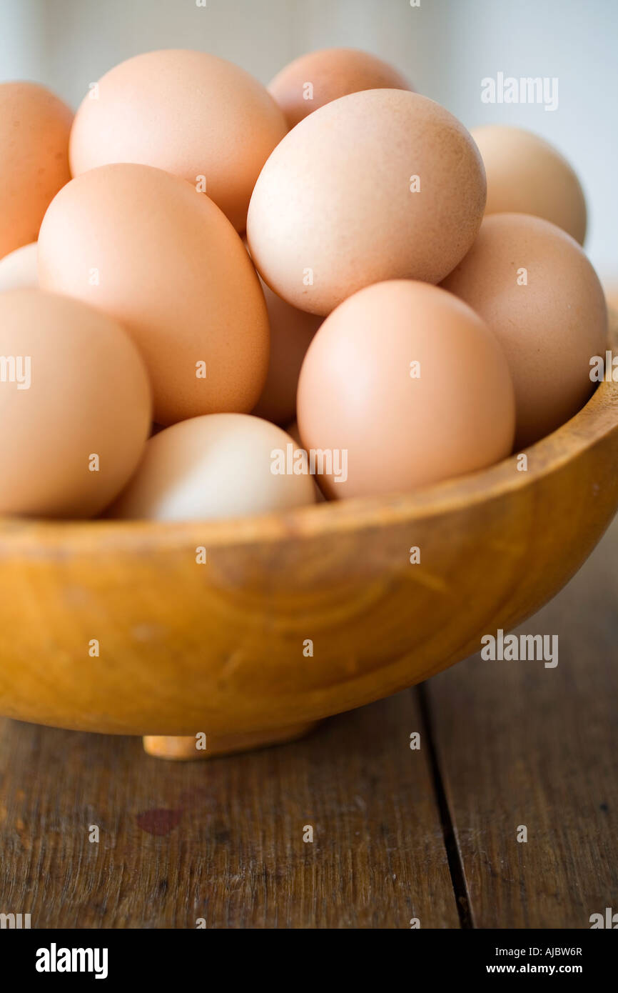 Très grand Les Œufs de poules en liberté dans un bol en bois Banque D'Images