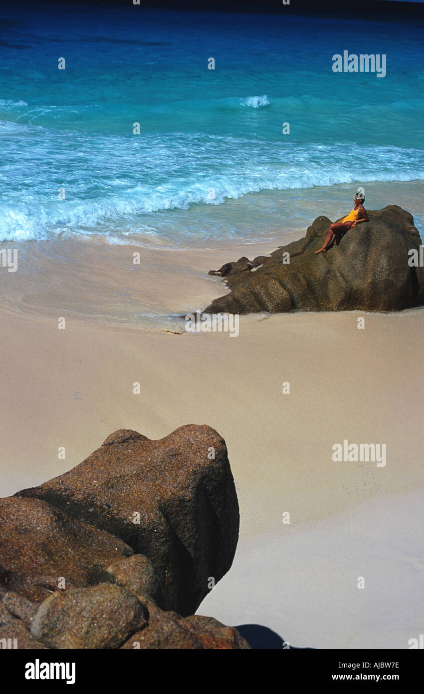 Woman lying on rock at beach. soleil, Seychelles Banque D'Images