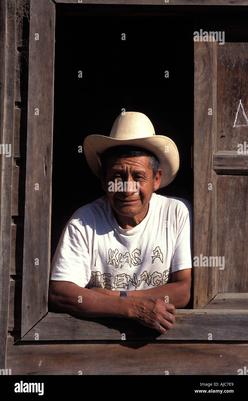 L'homme de San Lucas Toliman scrutant d'une fenêtre de sa maison en bois Le Lac Atitlan Guatemala Banque D'Images