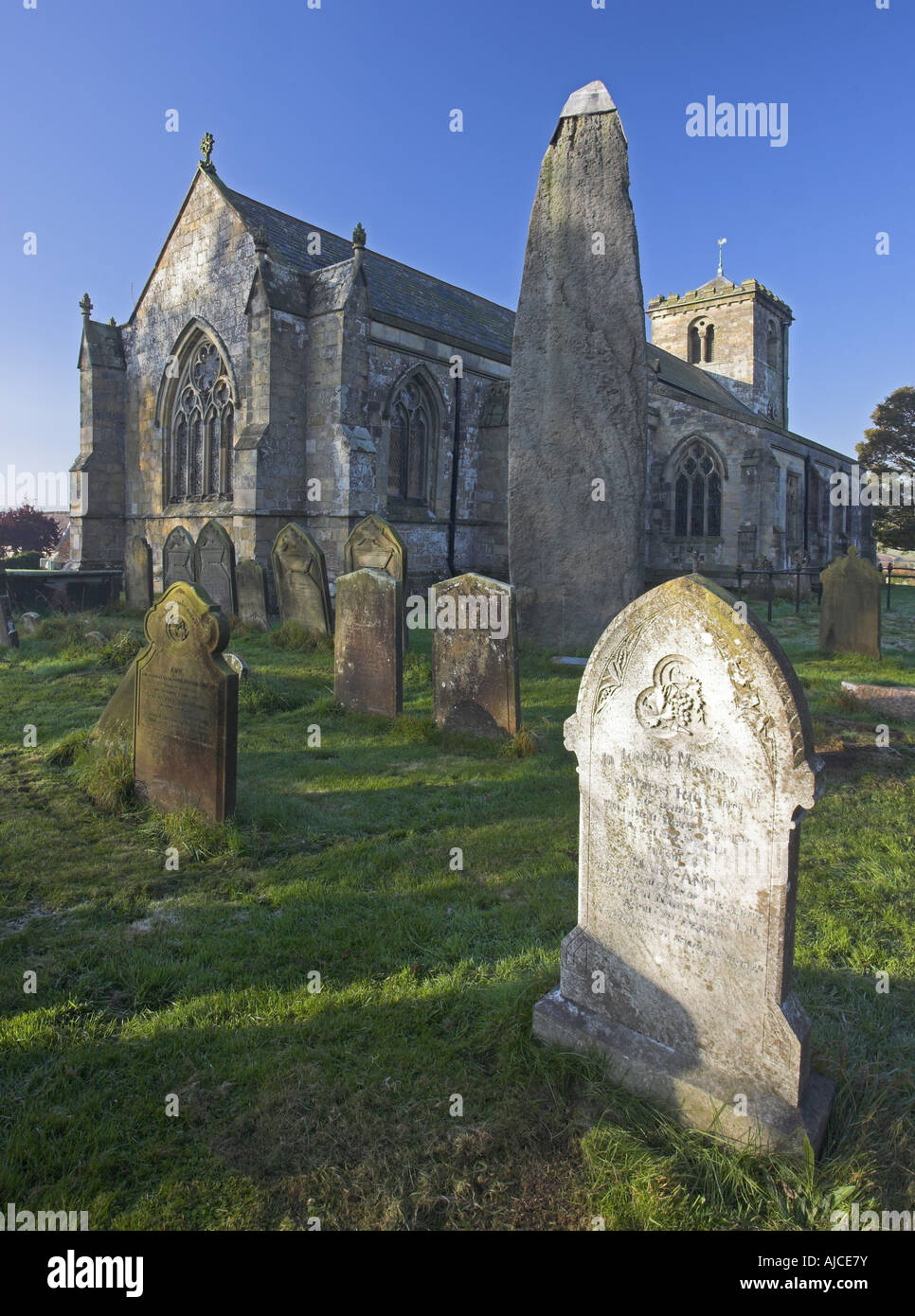 L'église paroissiale de tous les Saints et les anciennes pierre monolithe à East Rudston sur l'English Channel, North Yorkshire, UK Banque D'Images