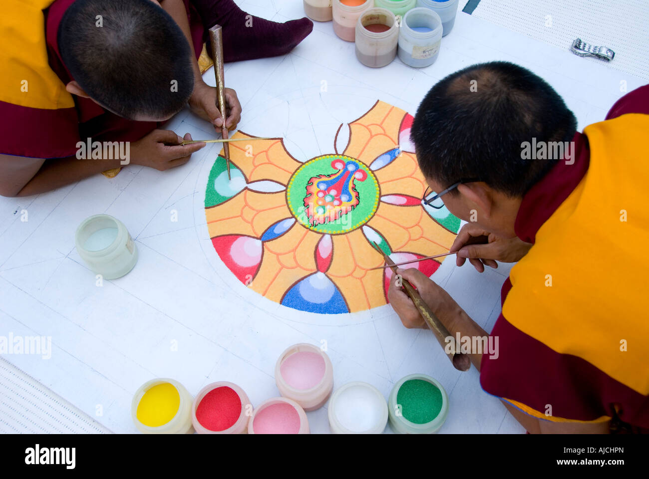 Moines tibétains travaillant sur mandala de sable Banque D'Images