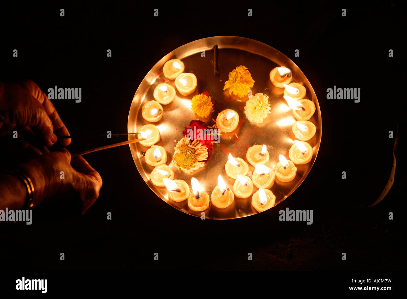 Un dévot en terre d'éclairage Lampes pour une cérémonie religieuse Banque D'Images