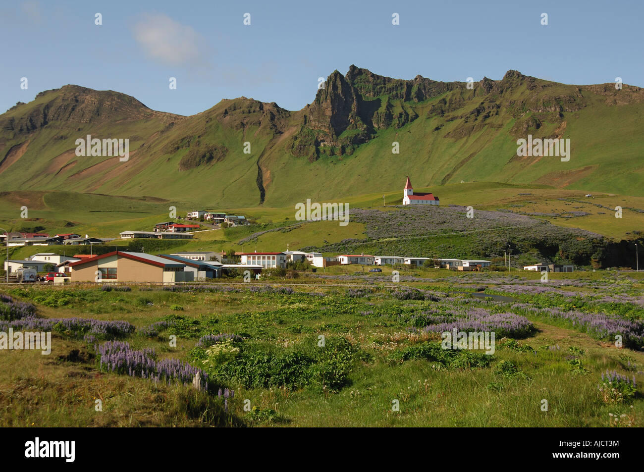 La ville de Vik le sud de l'Islande avec son église au-dessus de tous les rochers et pentes abruptes sous Banque D'Images