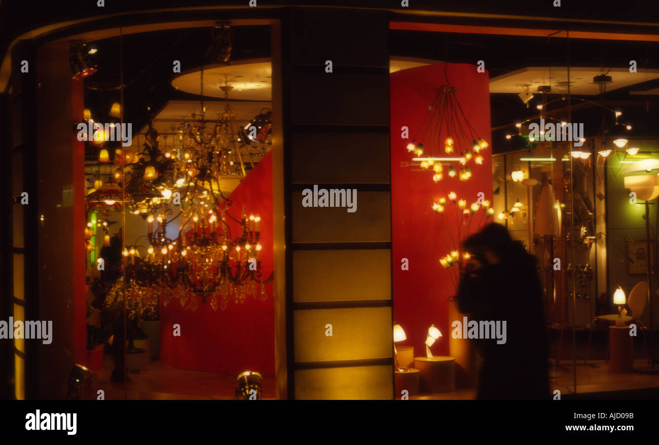 Couple marchant près d'un magasin d'éclairage dans le centre de Londres la nuit. Banque D'Images