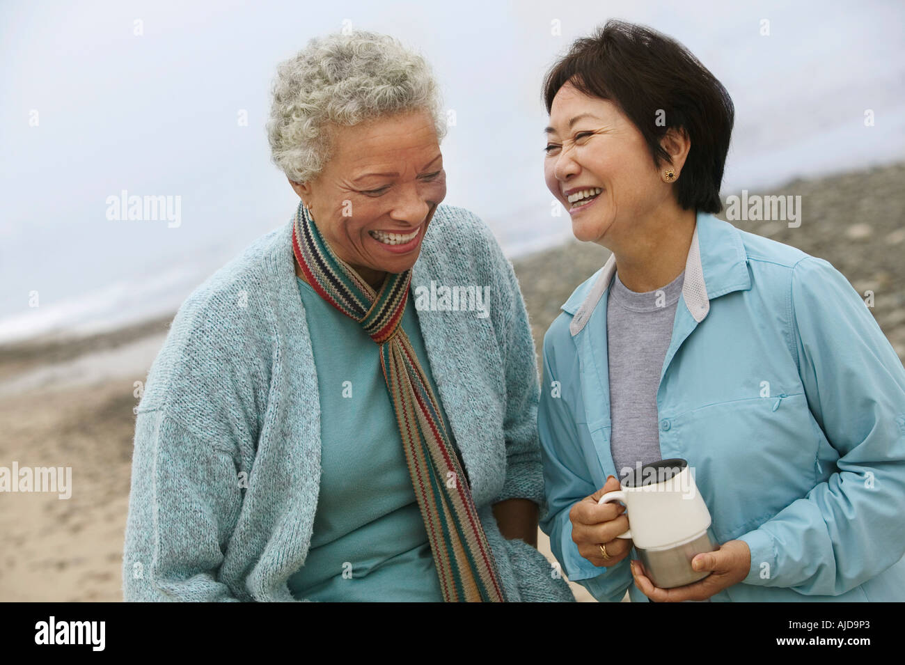 Deux amis parler des femmes ethniques on beach Banque D'Images