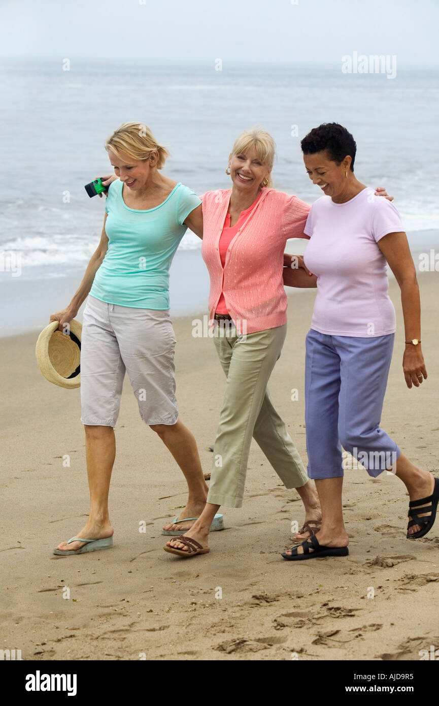 Trois femmes walking on beach Banque D'Images