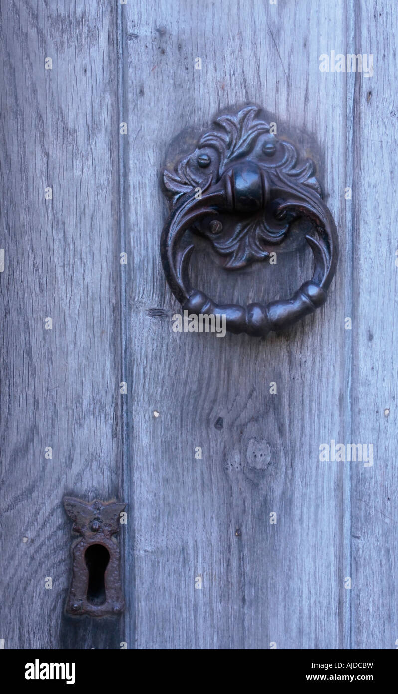 Heurtoir de porte en fer forgé décoratif et écusson sur la vieille porte de bois Banque D'Images