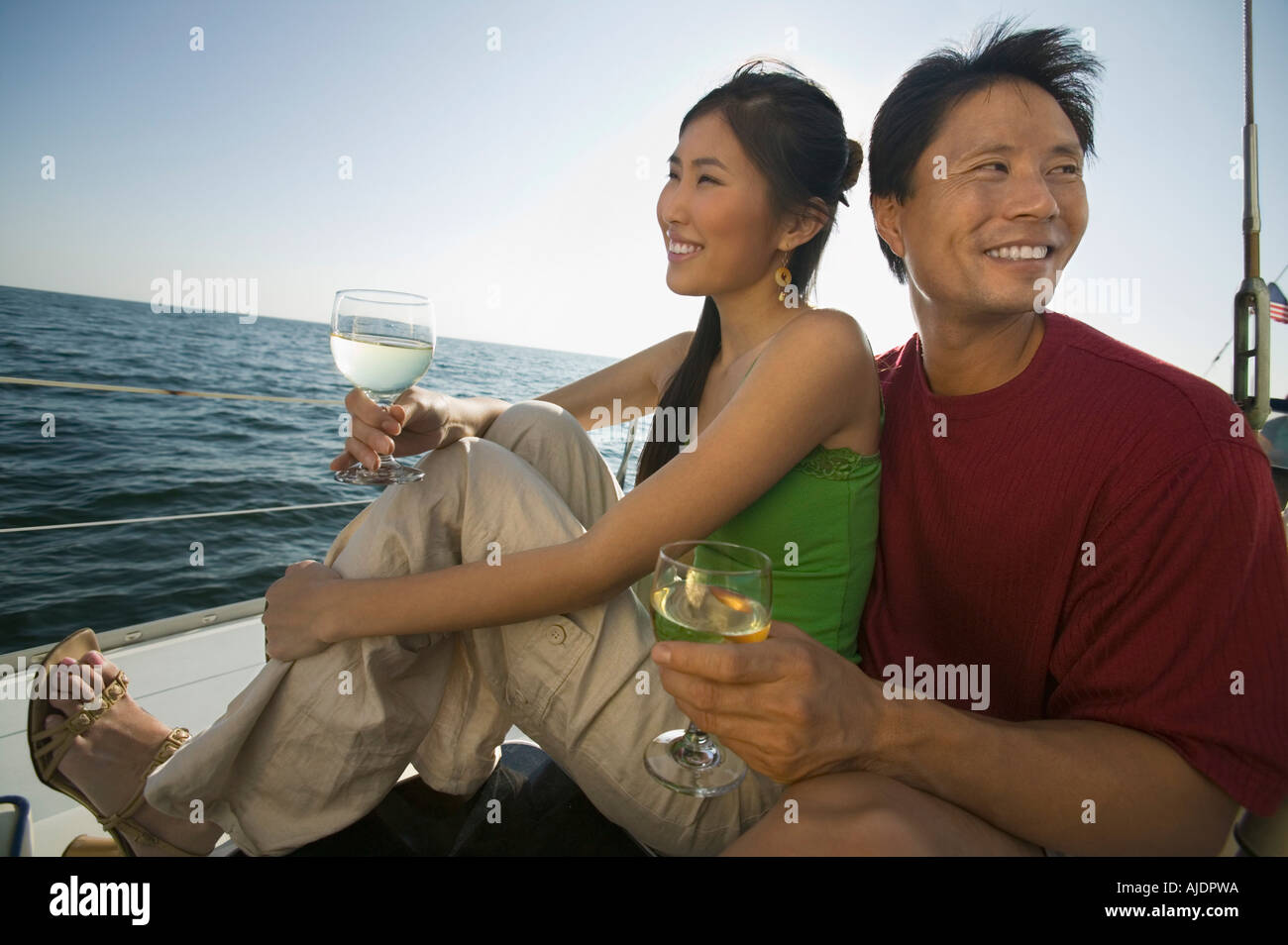 Vin blanc dinking couple on boat Banque D'Images