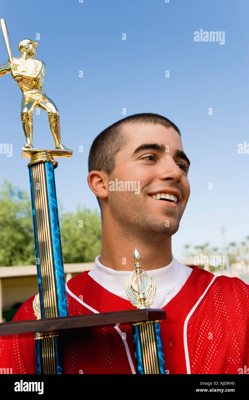 Baseball player holding trophy sur terrain Banque D'Images