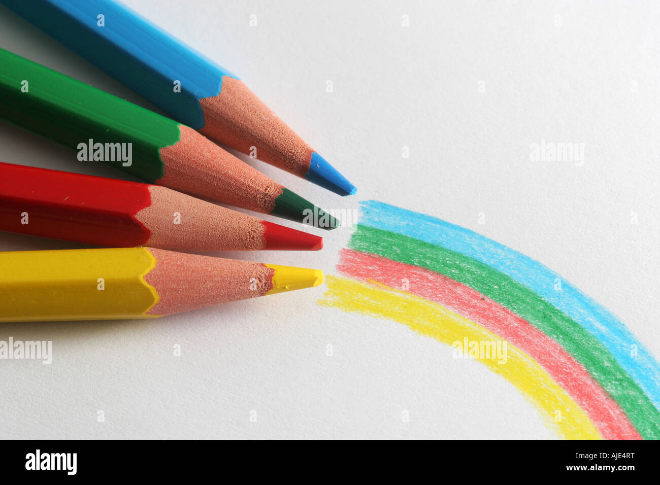 Un plan macro sur l'extrémité avant d'un groupe de crayons de couleur isolé sur arc-en-ciel blanc dessiné à l'avant Banque D'Images
