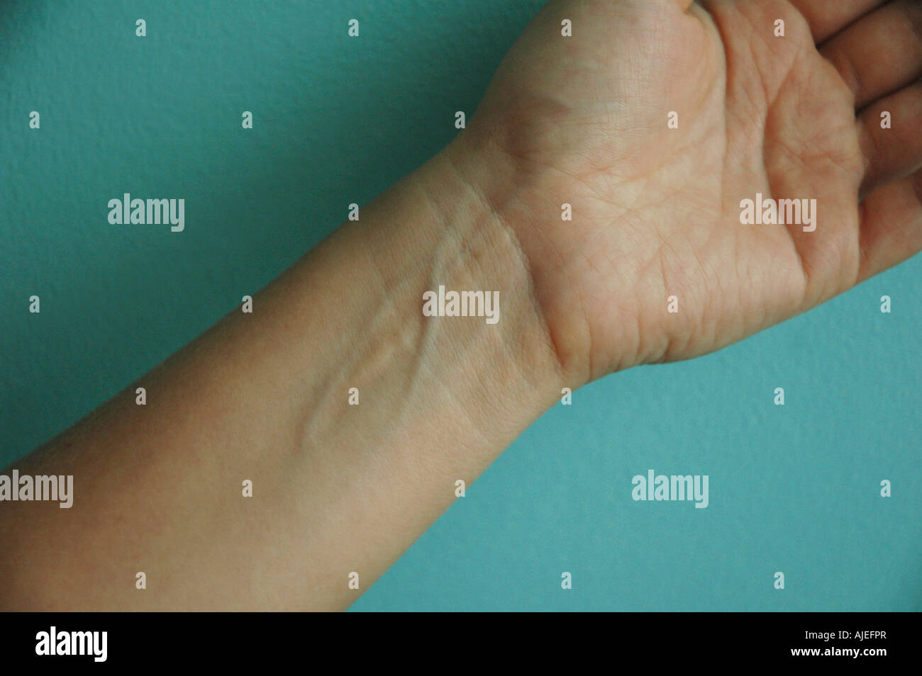 Close up of woman's poignet sur fond bleu turquoise Banque D'Images