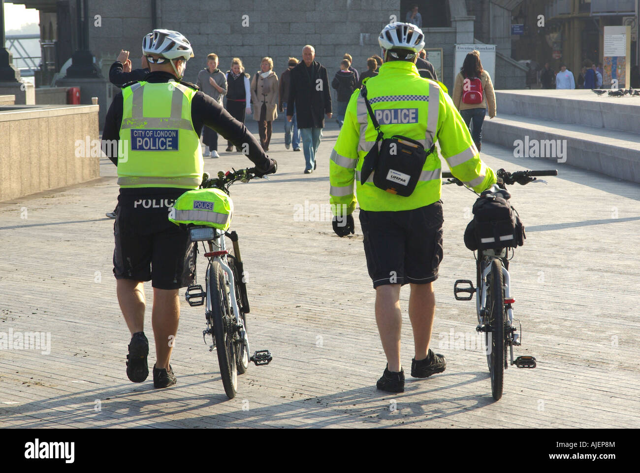 Ville London cycling constables démontés pour une patrouille à pied sur le côté sud de la Tamise près de Tower Bridge et le City Hall Banque D'Images