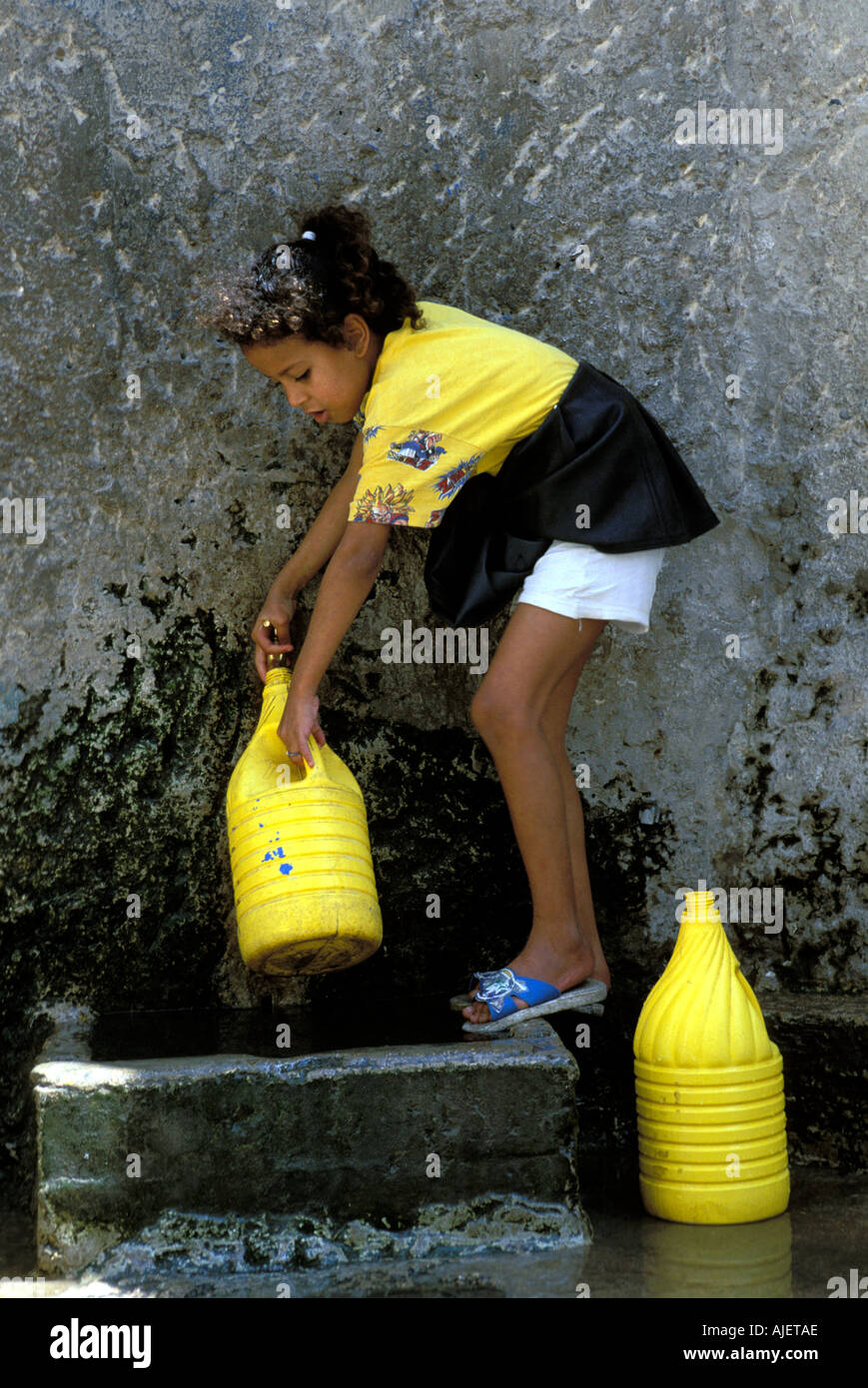 Une fille d'Essaouira la collecte de l'eau dans les pots Banque D'Images