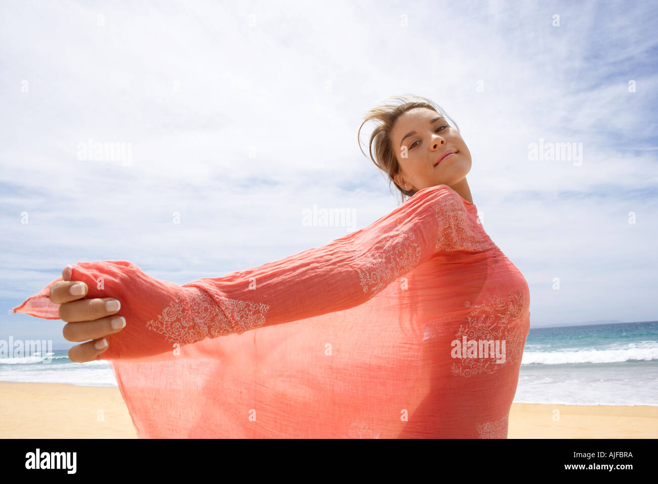 Jeune femme au châle sur plage, vue latérale Banque D'Images