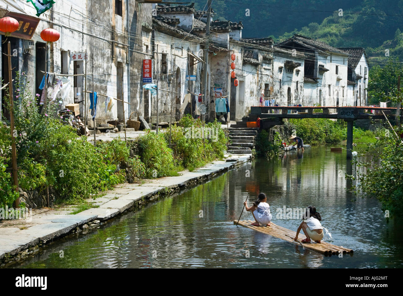 Canal et ancien village de Likeng filles jouent sur radeau en bambou Wuyuan County Chine Banque D'Images