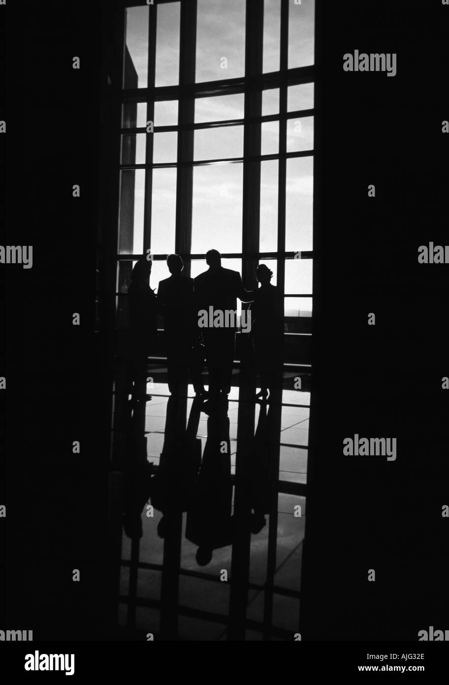 La silhouette du groupe de gens d'affaires de parler par la fenêtre grand hall Banque D'Images