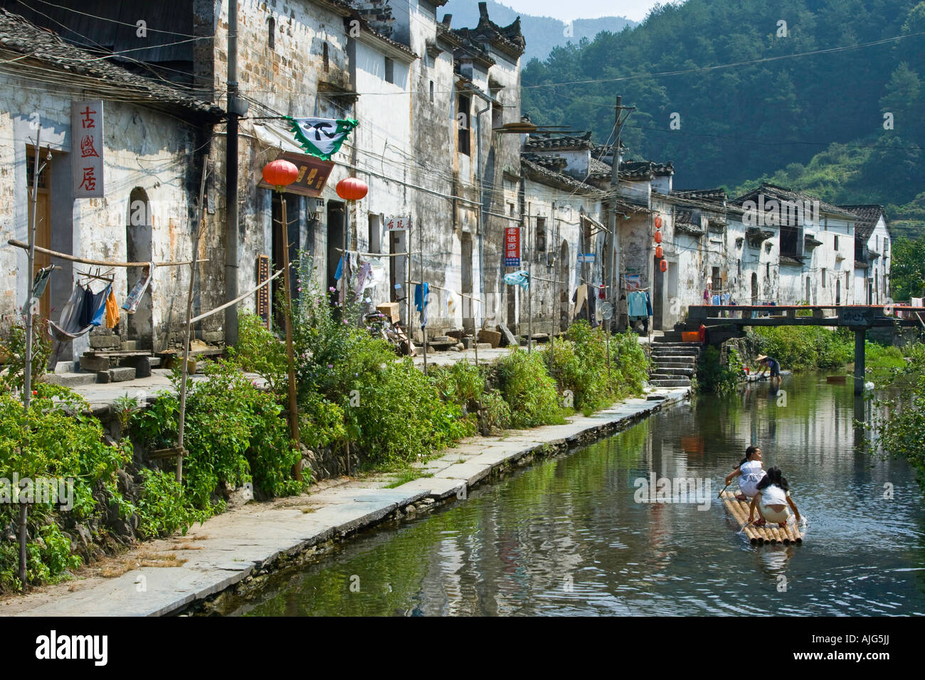 Canal et ancien village de Likeng filles jouent sur radeau en bambou Wuyuan County Chine Banque D'Images