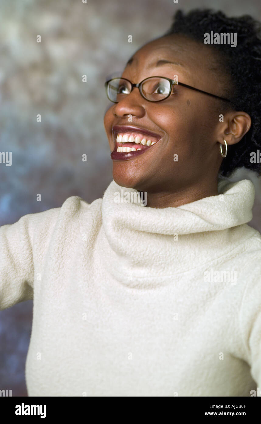 Portrait d'une jeune femme afro-américaine portant un chandail à col roulé blanc sur le fond de studio Banque D'Images