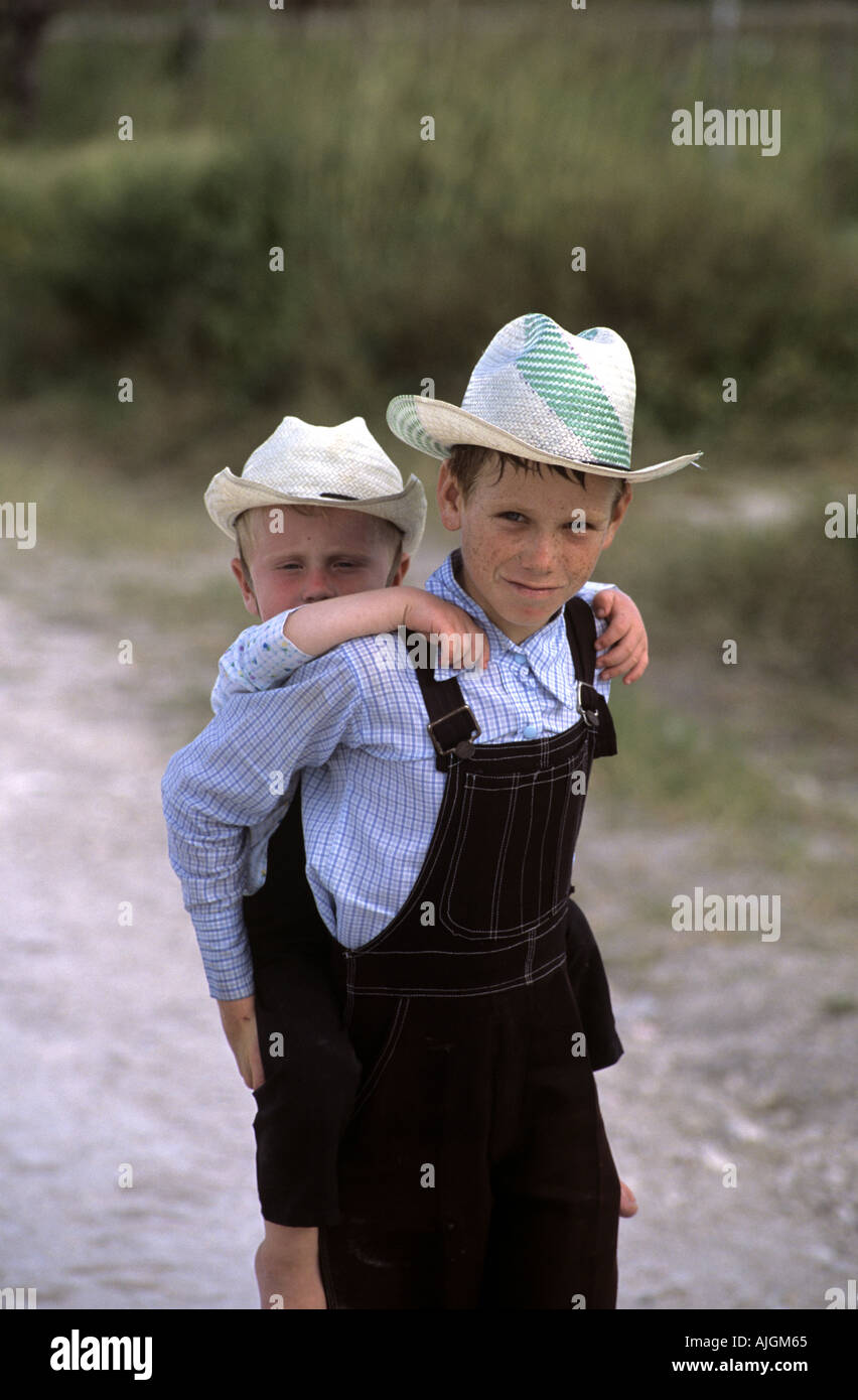 Boy giving Mennonite piggy back ride, près de Lamanai, Orange Walk District, Belize, en Amérique centrale. Banque D'Images