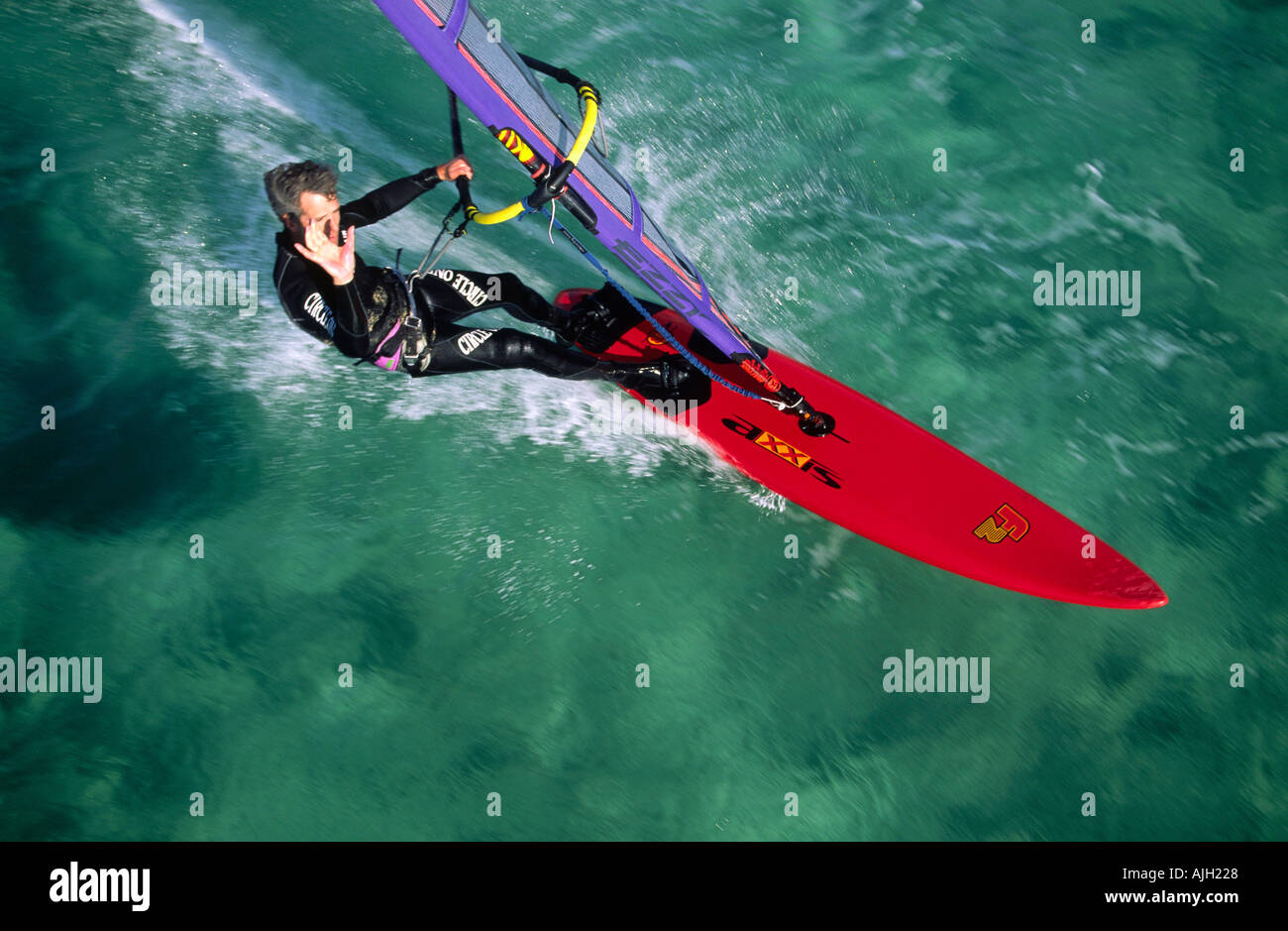 Vue aérienne de planche à voile en agitant une main rouge de l'eau de mer émeraude clair Banque D'Images