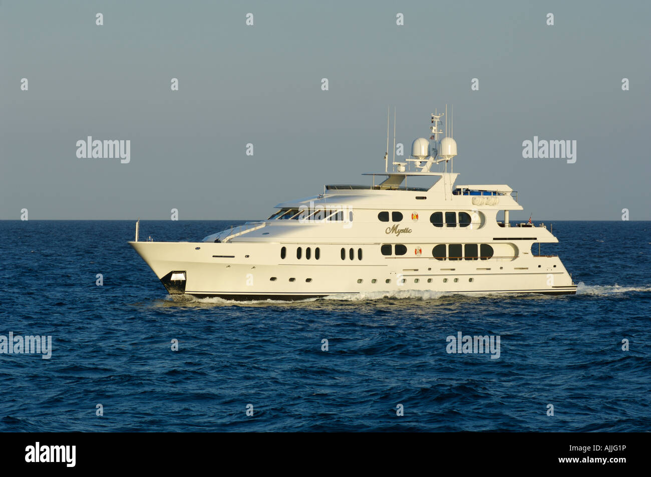 Un grand yacht à moteur en croisière au coucher du soleil sur la côte de Floride Banque D'Images