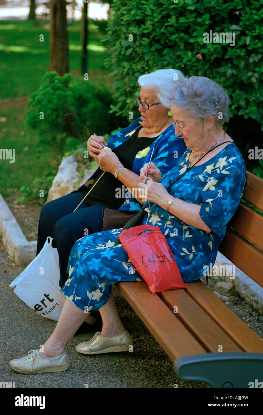 Deux vieilles dames le tricot sur un banc de parc dans le Parc des Arènes de Cimiez, Nice, sur la Côte d'Azur - French Riviera Banque D'Images