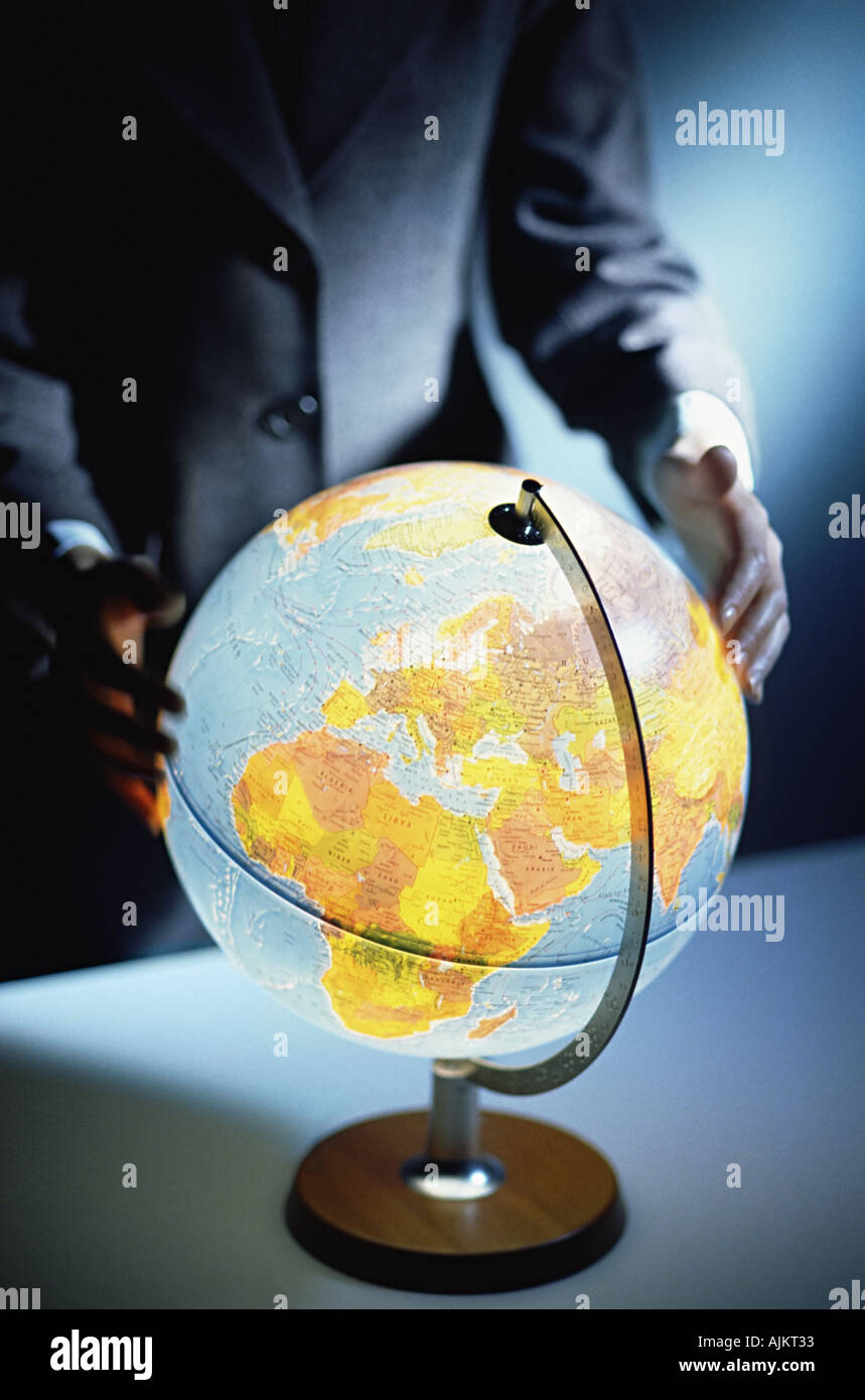 Businessman touching a globe Banque D'Images