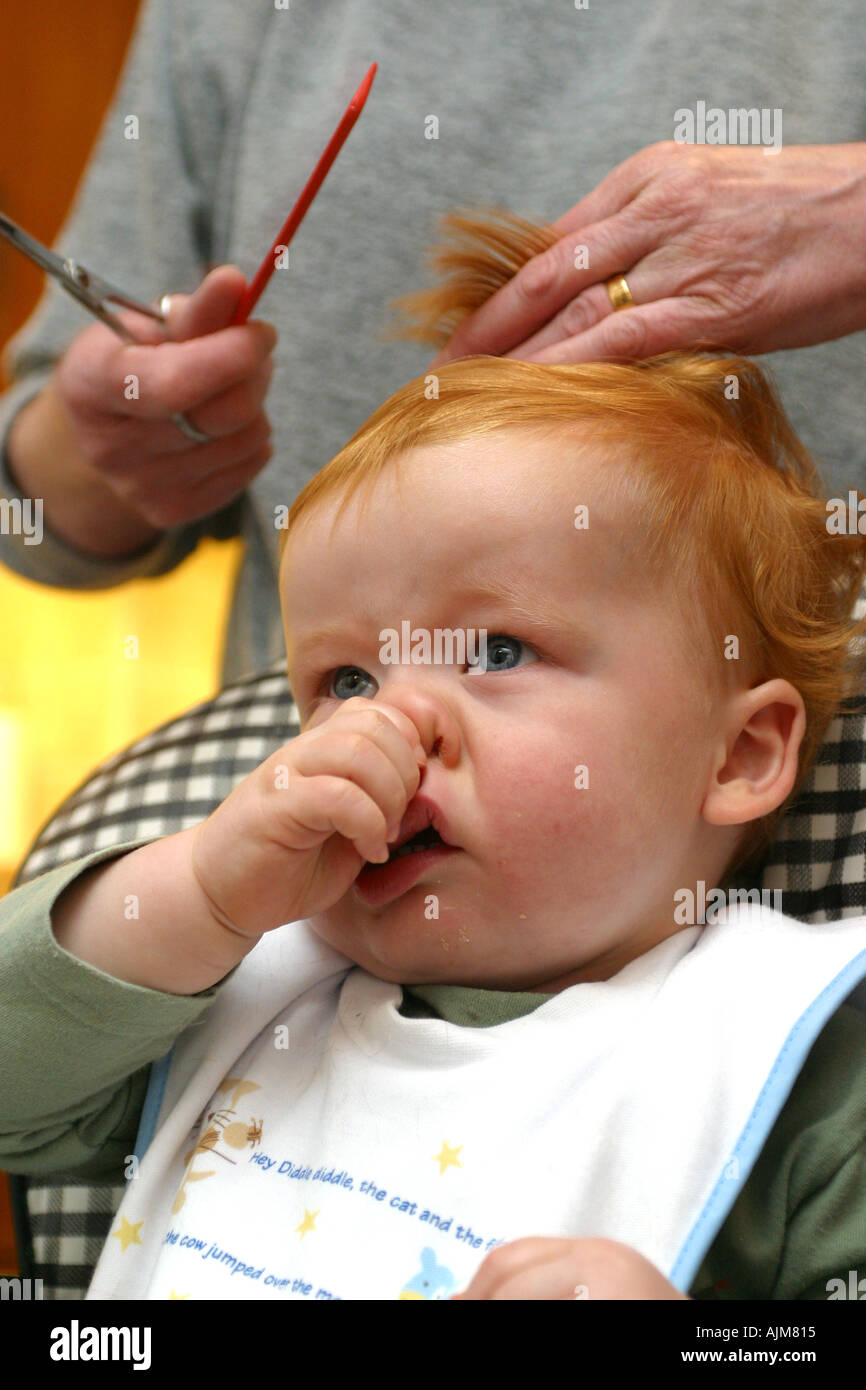 Un bébé ayant sa première coupe de cheveux âgés de 1 ans, un bébé est la  lutte contre la coiffure et s'indigner Photo Stock - Alamy