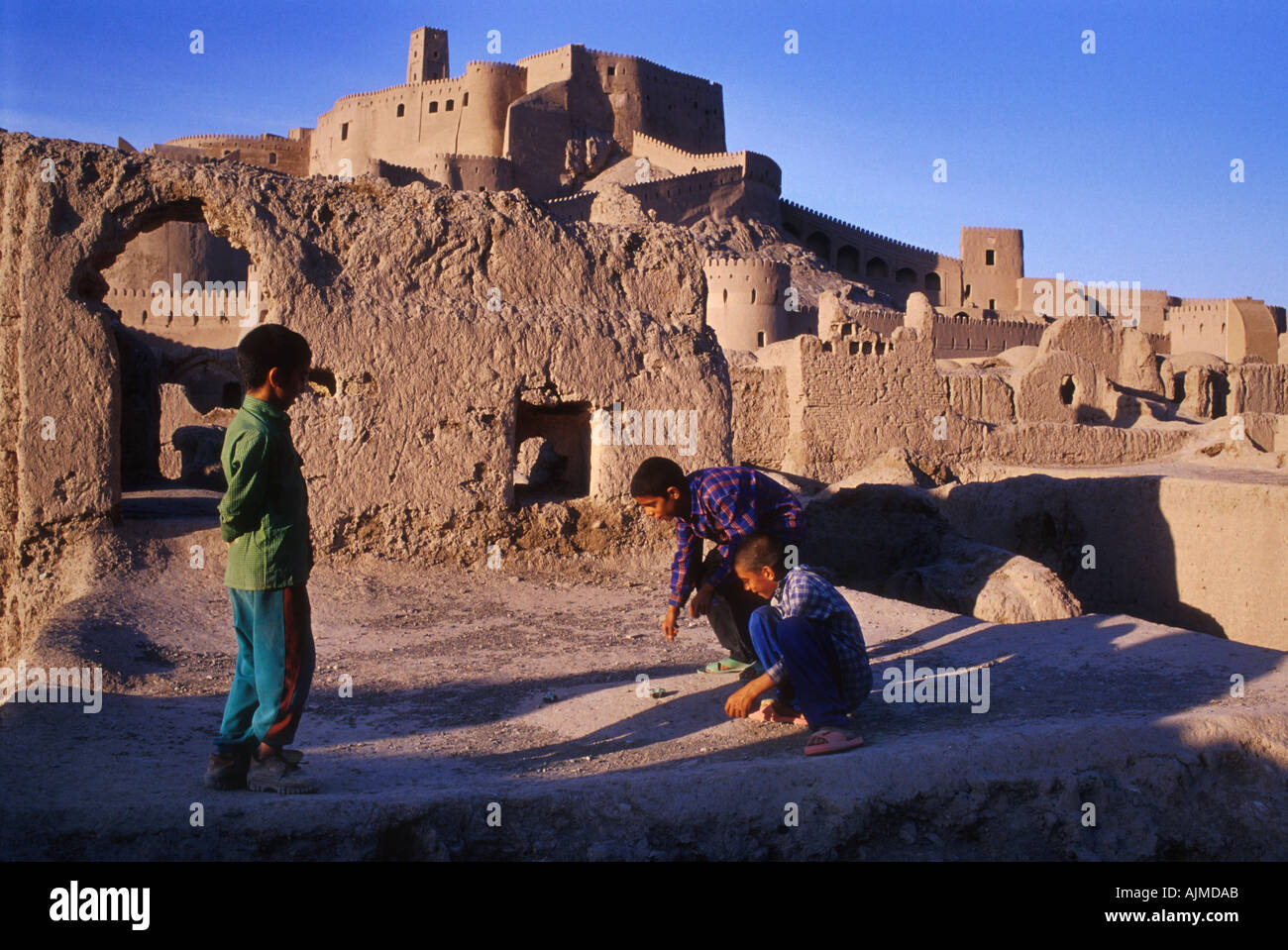 Enfants jouant en face de l'ancienne citadelle de Bam, Iran Banque D'Images