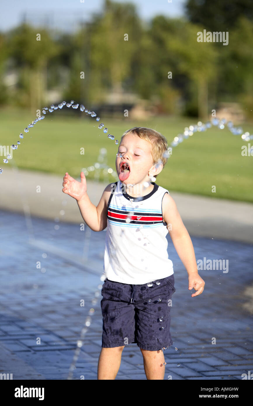 Jeune garçon de fontaine à eau potable Banque D'Images