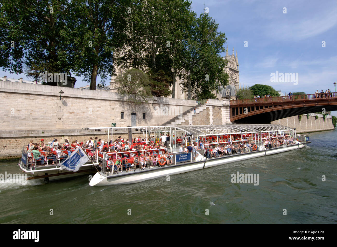 Un "bateau-mouche" Boat Cruises passé la cathédrale Notre Dame sur la Seine à Paris. Banque D'Images