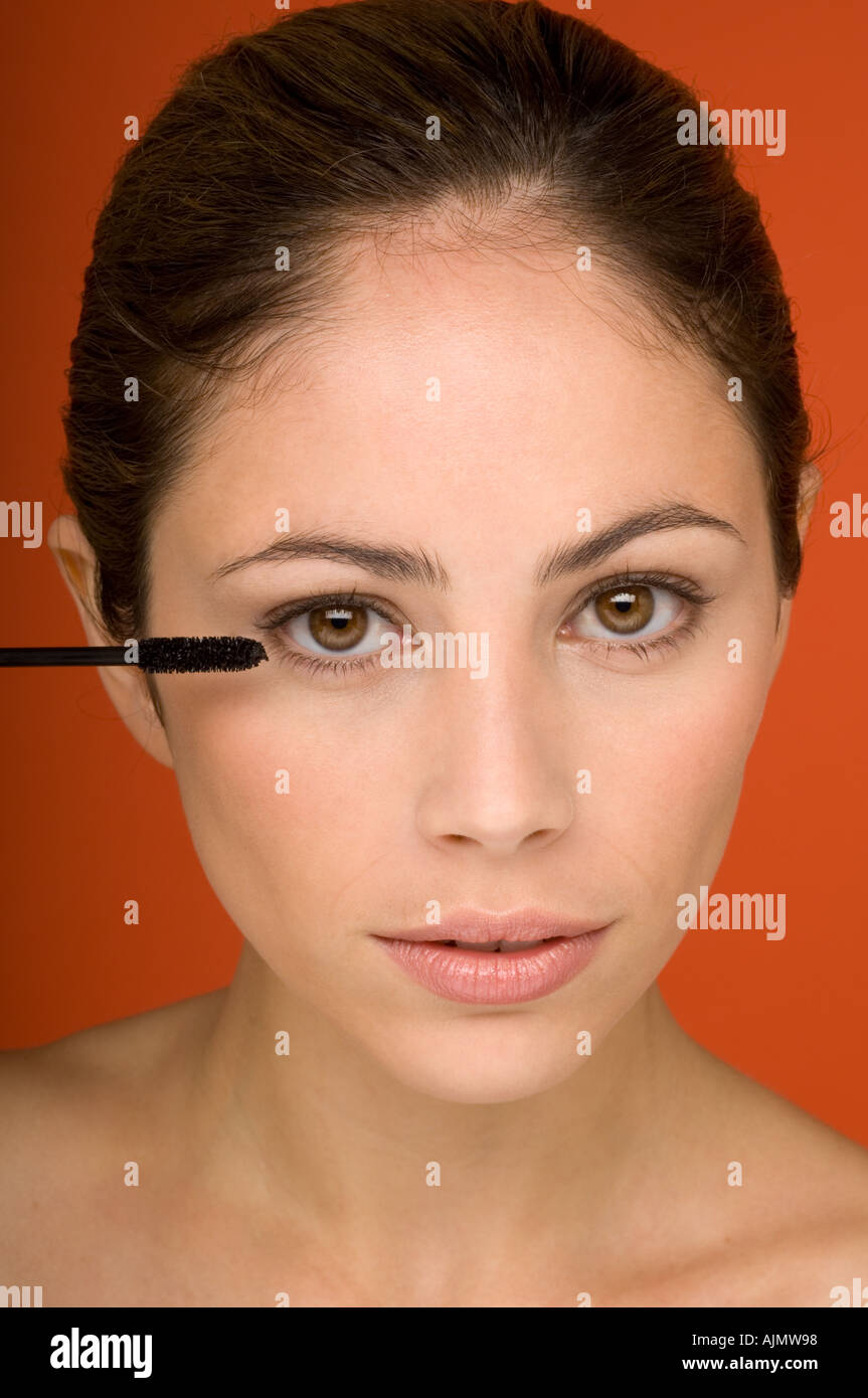 Young woman applying mascara certains Banque D'Images