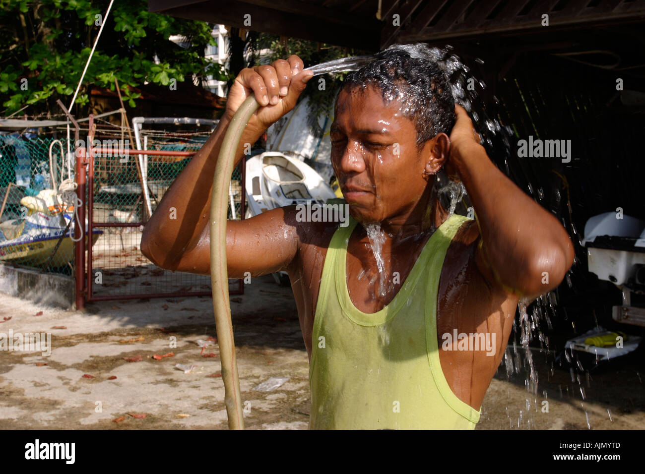 Un jeune homme de Malaisie prend une douche de fortune par la plage de Batu  Ferringhi, l'île de Penang, en Malaisie Photo Stock - Alamy