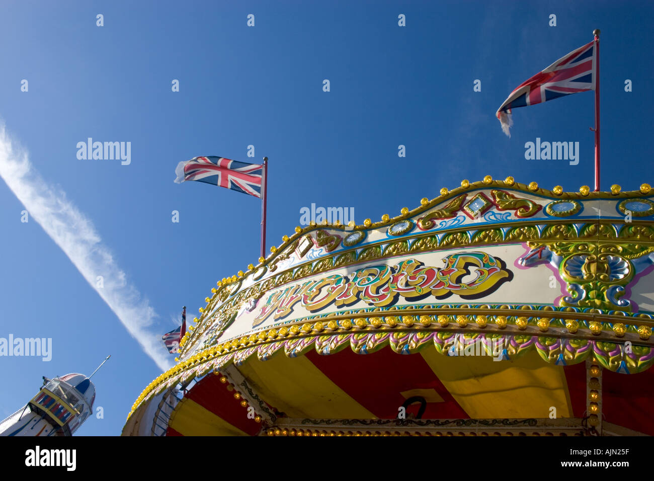 Merry go round avec helter skelter en fond du ciel et nuages drapeaux Brighton Banque D'Images