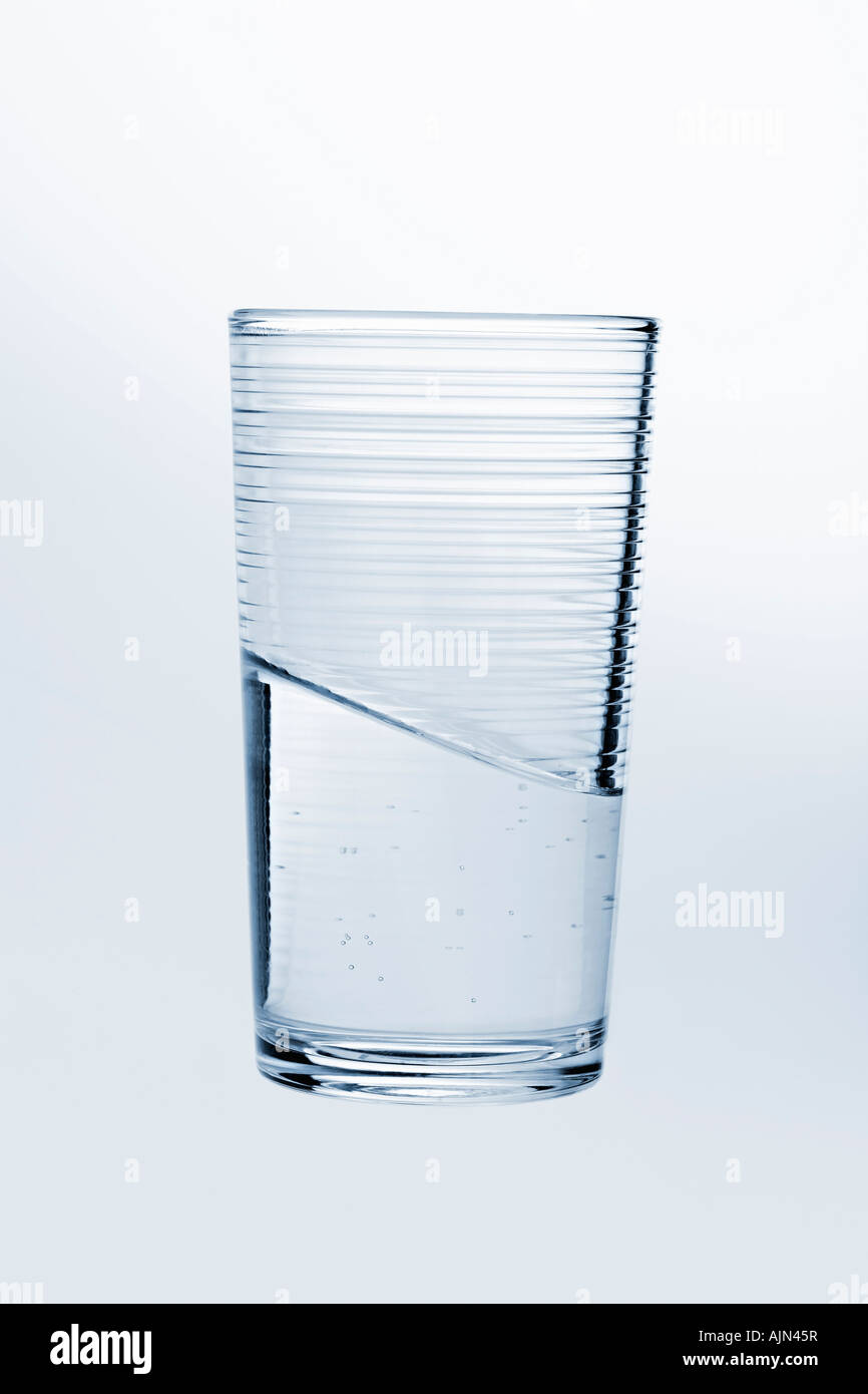 Seul verre d'eau avec niveau d'eau impossible illusion étrange surréaliste impossible Banque D'Images