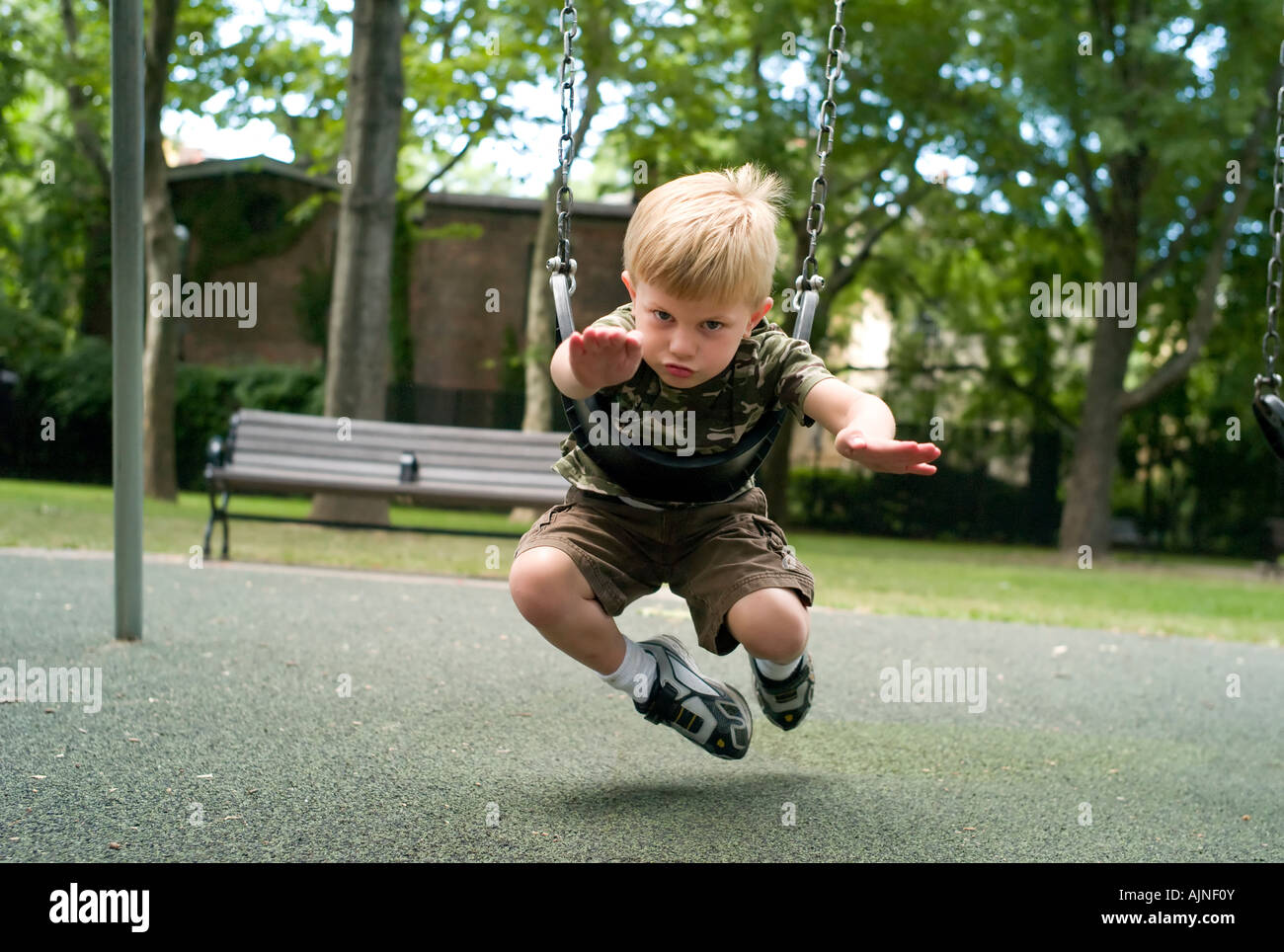 Enfant prétendant à voler sur aire de swing Banque D'Images