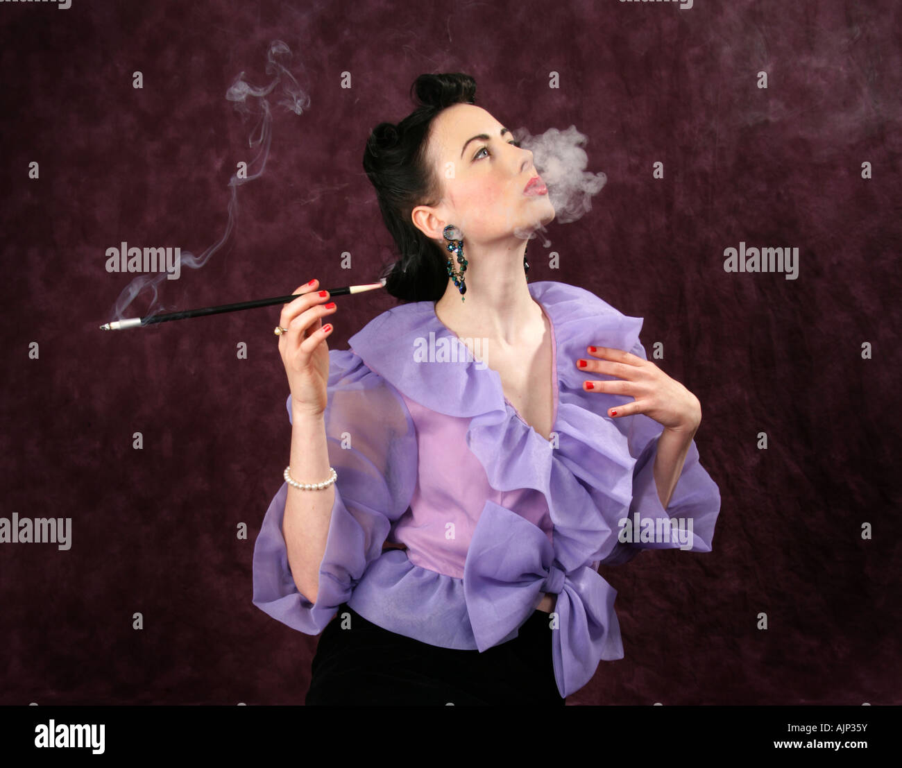 Un Pin Up Girl in a Purple Blouse tenant un porte-cigarette, et le tabagisme Banque D'Images