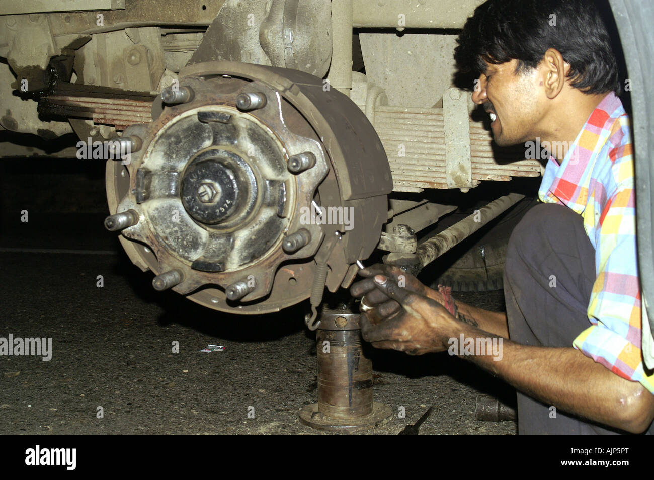 L'homme indien technicien conducteur de bus cassée réparation roue frein  brûlé coach sur la nuit l'Inde dangereuse transport dangereux Photo Stock -  Alamy