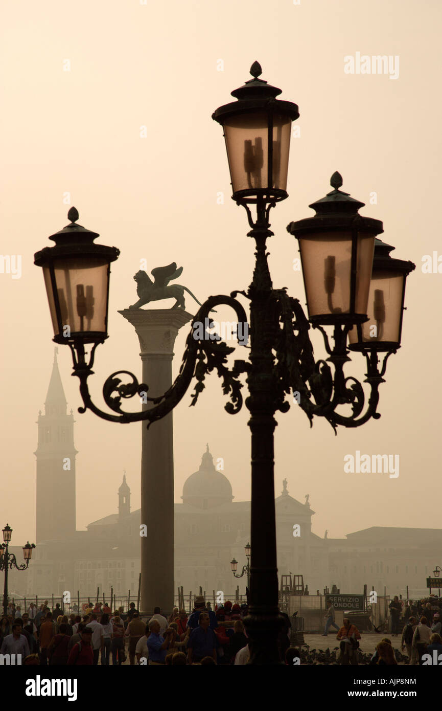 Italie Vénétie Venise foule touristique en Piazzetta sous lampadaire orné de Palladio avec San Giorgio Maggiore dans le brouillard de la lagune Banque D'Images