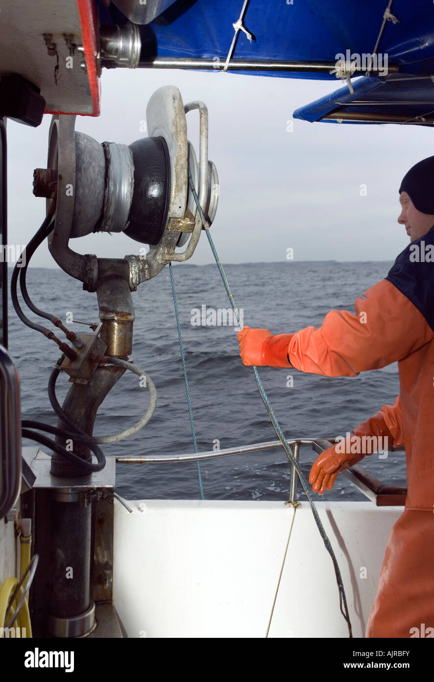 Nordic pêcheur sur une descente en bateau sur le fil à homard à la mer avec l'aide d'un transporteur d'électronique. Mer de Kattegat, la Suède Banque D'Images