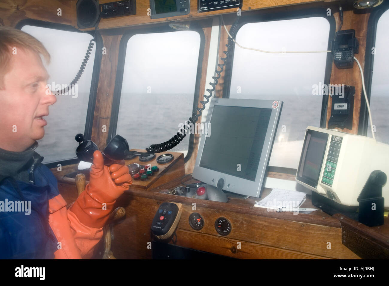 Conversations au pêcheur radio VHF dans la cabine de son bateau Kattegat mer Suède Europe de l'Ouest Banque D'Images
