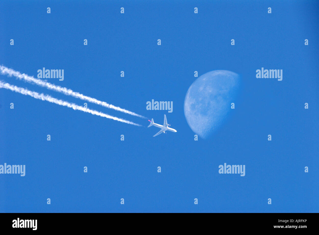 Un avion passe la lune dans le ciel au cours d'une soirée de fin d'été Banque D'Images