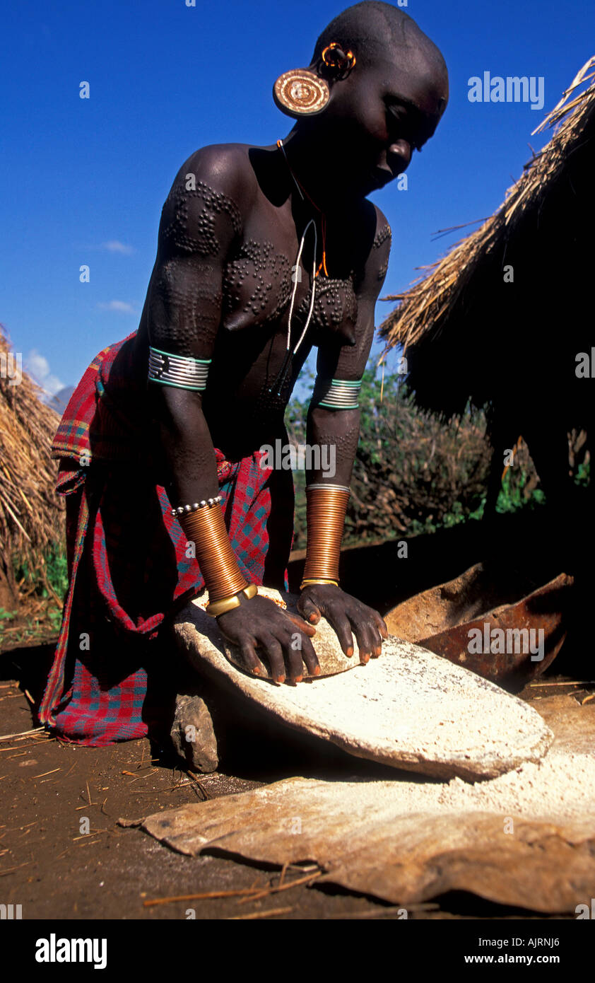 Broyage des graines de santé femme Surma une source importante de nourriture de tribu Surma, à l'ouest de la rivière Omo en Ethiopie. Banque D'Images