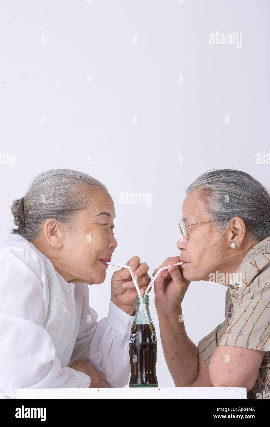 Profil de côté deux femmes âgées partageant une boisson froide Banque D'Images