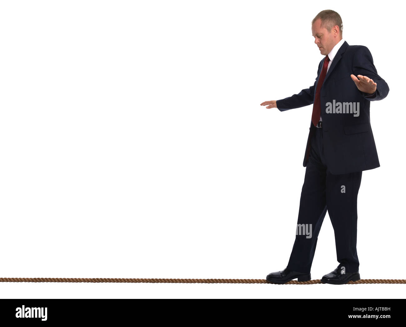 Businessman walking le long de la corde raide en essayant de garder son équilibre Banque D'Images