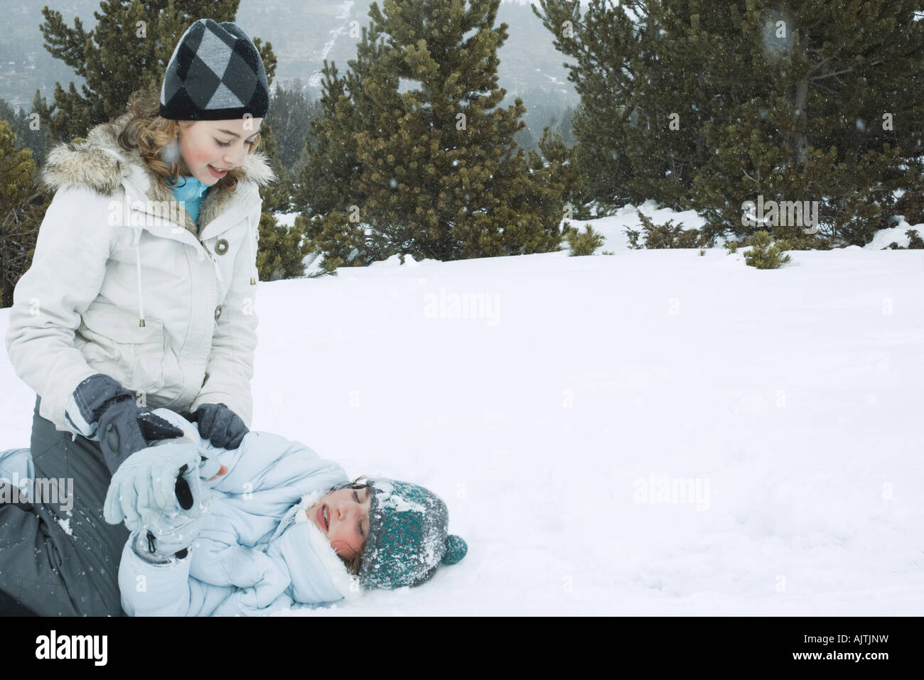 Deux adolescentes playfighting dans la neige Banque D'Images